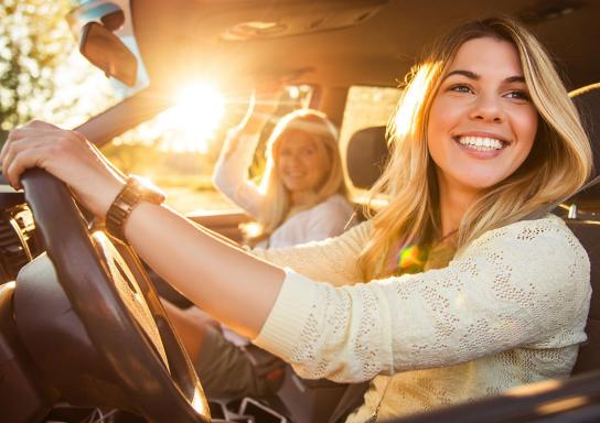 Blick aus einem Auto auf zwei Frauen, die sich unterhalten und spazieren gehen..