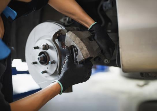 Großansicht einer Hand an einer Bremsscheibe an einem Auto.