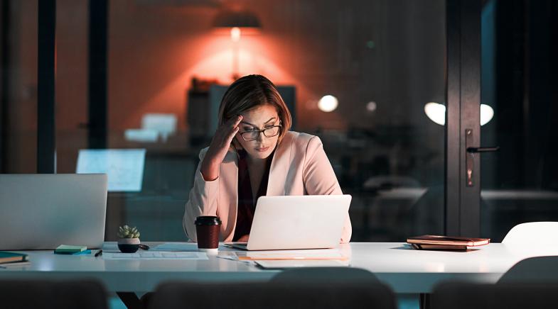 Frau nachts arbeitend im Büro