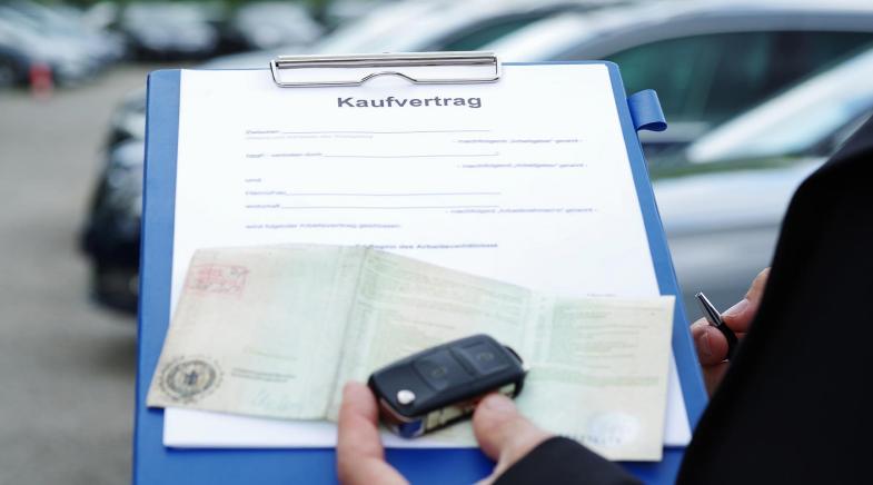 Fahrzeugschein, Kfz-Kaufvertrag und Autoschlüssel