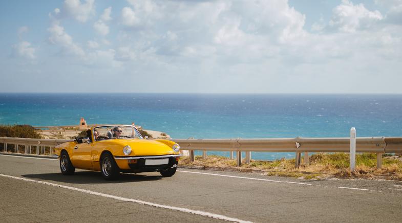 Gelbes Auto auf Straße am Strand