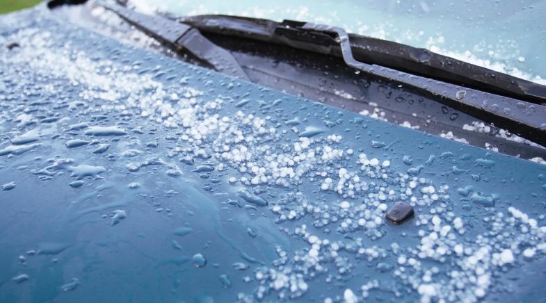 Hagel auf der Motorhaube eines Autos.