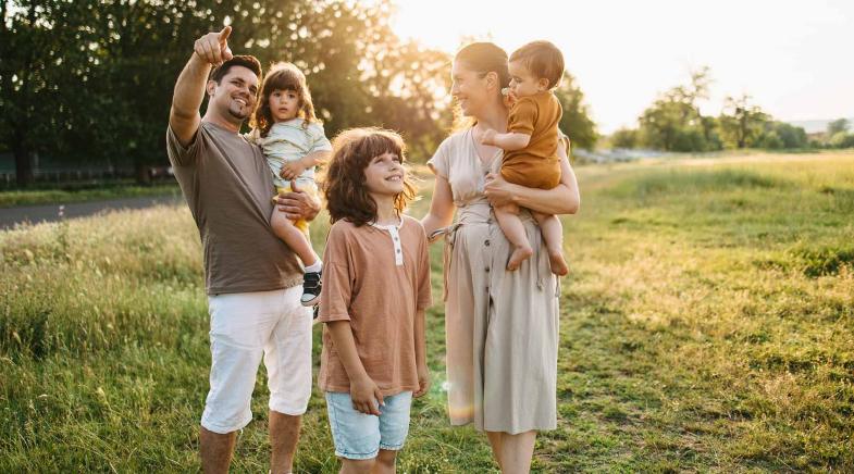 Familie mit 3 Kindern auf einer Wiese