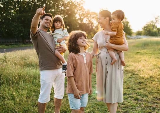 Familie mit 3 Kindern auf einer Wiese