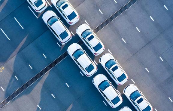 Zwei Reihen weißer Autos von oben.