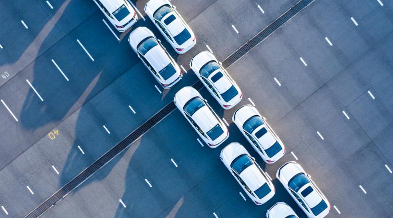 Zwei Reihen weißer Autos von oben.