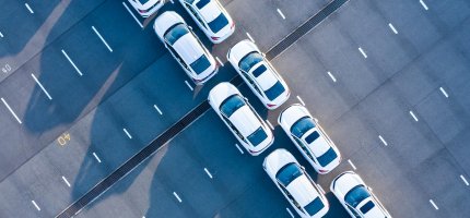 Zwei Reihen weißer Autos von oben.