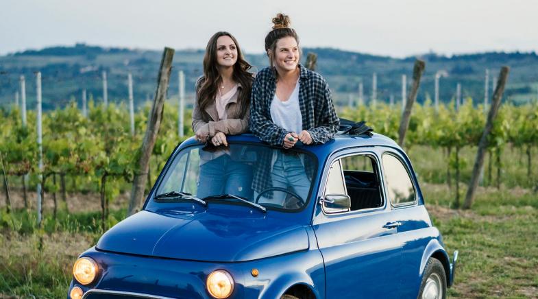 Zwei Frauen schauen aus dem Dach eines Oldtimer