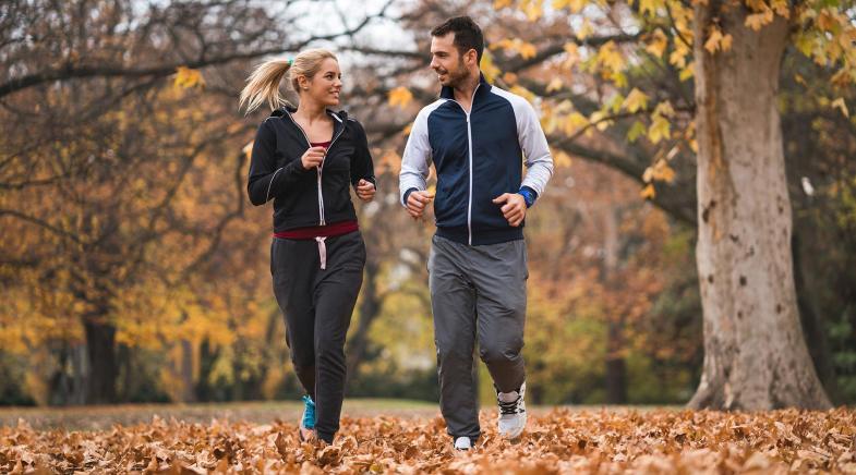 Zwei Jogger im herbstlichen Park.