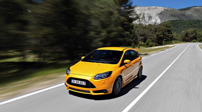 Ein gelbes Auto mit Wechselkennzeichen fährt auf einer Straße.