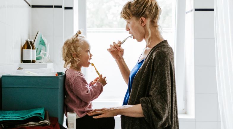 Mutter und Tochter putzen Zähne