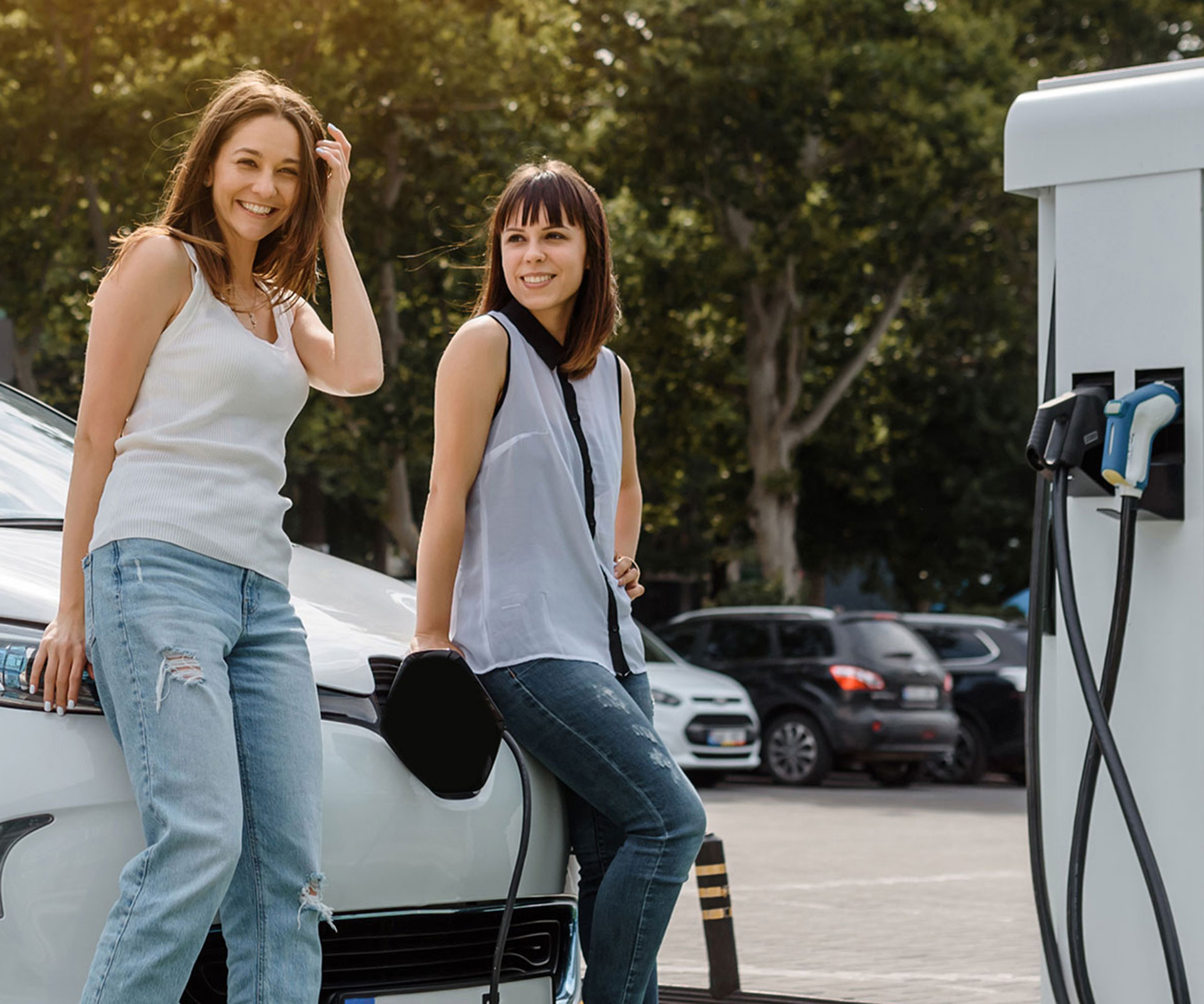Zwei Frauen laden ihr E-Auto an einer Ladesäule.