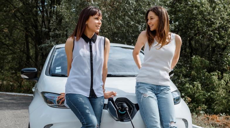 Zwei Frauen vor einem ladenden Elektorauto