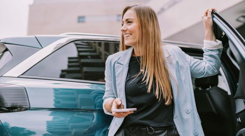 Eine Person stellt Warndreieck auf, im Hintergrund fährt ein Auto