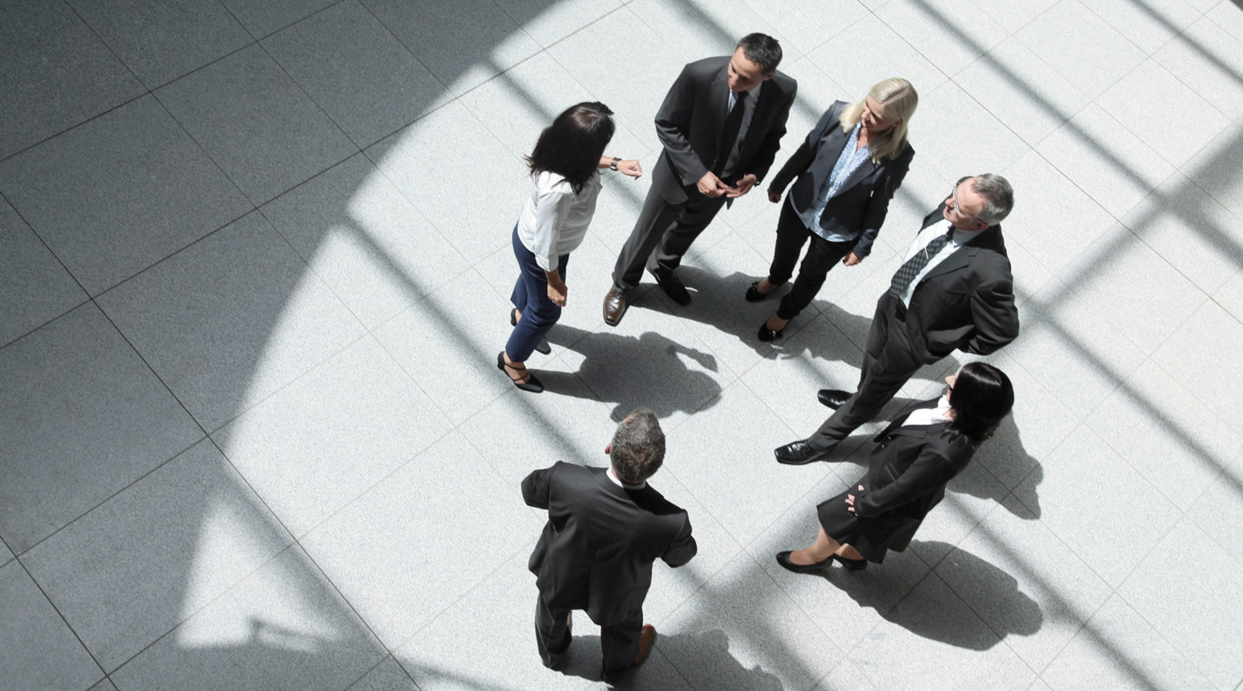 Mehrere Personen stehen im Foyer und unterhalten sich.