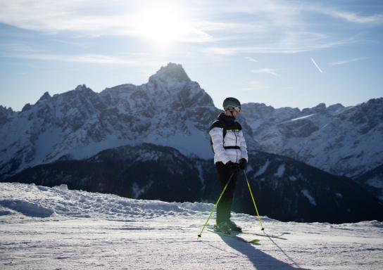 Titelbild zum Video: Die wichtigsten Tipps rund um Ausrüstung, Sicherheit und Haftung von Andi Schuster. Ein Skifahrer steht im Schnee auf einem Berg, kurz vor der Abfahrt.